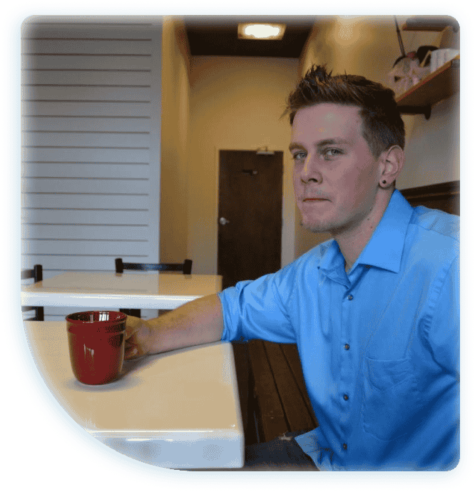 image of the owner sitting in a coffee shop with coffee in his hand